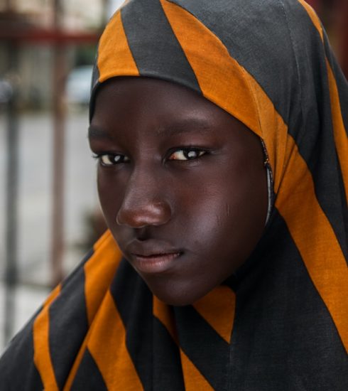 girl in black and orange striped head scarf in selective focus photography