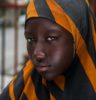girl in black and orange striped head scarf in selective focus photography