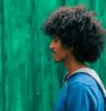 man facing right near green wall