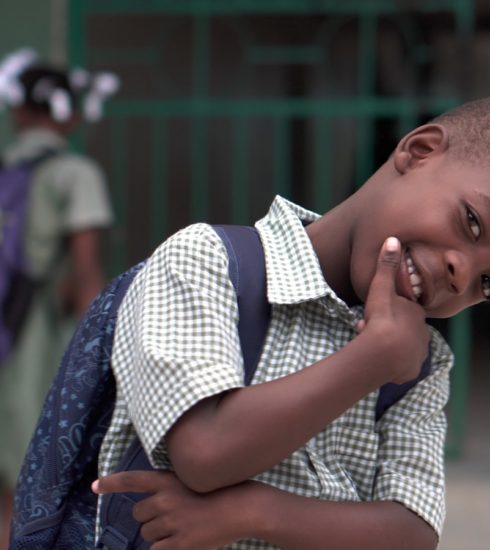 smiling boy with right hand on chin