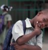 smiling boy with right hand on chin