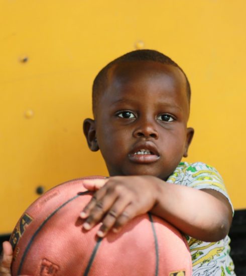 boy holding brown basketball