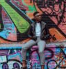 man sitting on concrete terrace with graffiti art