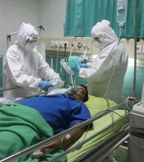 man in white medical scrub lying on hospital bed