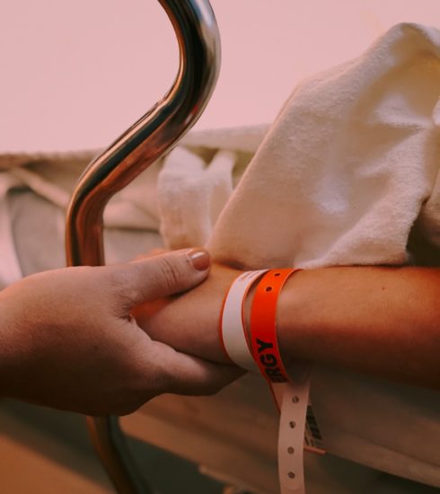 person wearing orange and white silicone band