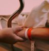 person wearing orange and white silicone band