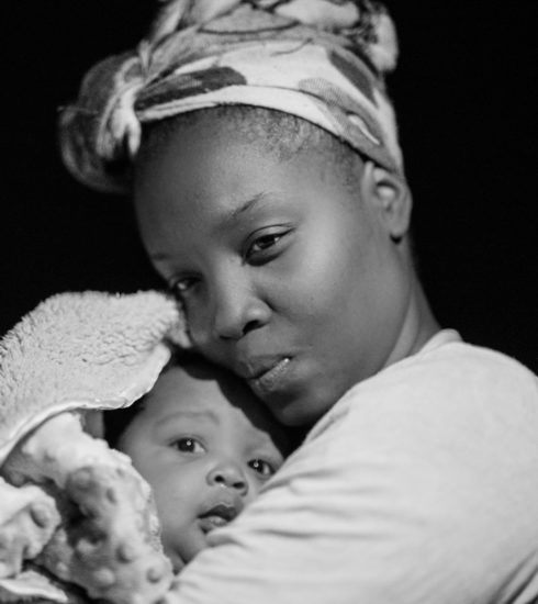 grayscale photo of woman carrying baby
