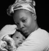 grayscale photo of woman carrying baby