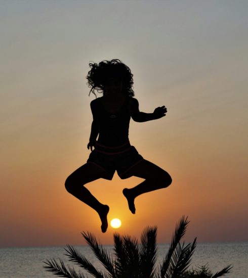 a silhouette of a woman jumping into the air