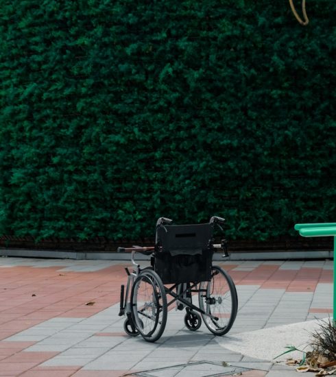 black bicycle parked beside green wall