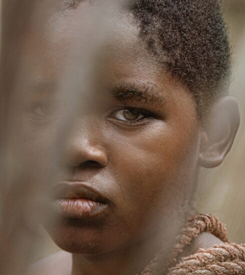 a close up of a person behind a fence
