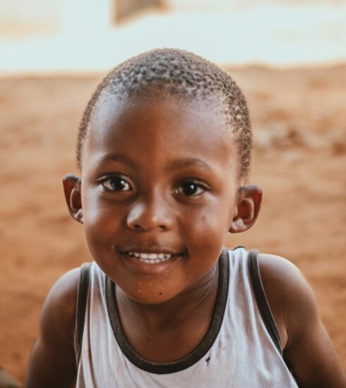a young boy is smiling at the camera